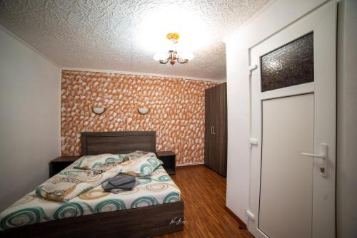 a small bedroom with a bed and a door at Casa Cosmina Arieseni in Arieşeni