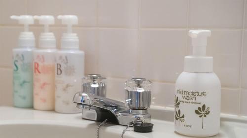 a bathroom sink with a bottle of lotion and a mixer at Hotel Viora in Owase