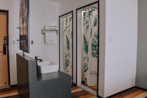 a bathroom with a sink and two glass doors at Fan's Hotel in Baybay