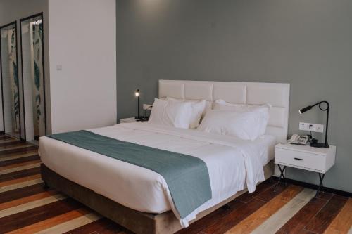 a bedroom with a large white bed and a night stand at Fan's Hotel Baybay in Baybay