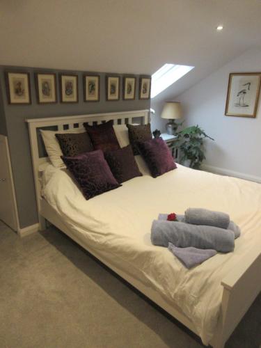 a bedroom with a large white bed with purple pillows at Straleel South in Carrick