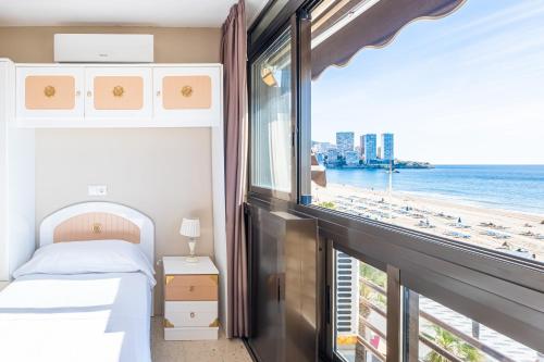 ベニドルムにあるLas Arenas 1-C Apartment Levante Beachのビーチの景色を望むベッドルーム1室(ベッド1台付)が備わります。