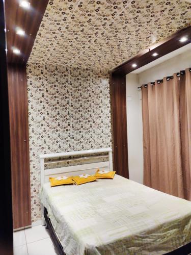 a bedroom with a bed with a patterned wall at Casa aconchegante in Campo Grande