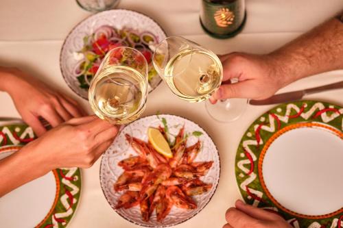 um grupo de pessoas bebendo vinho em uma mesa com comida em Hotel Palma em Odessa
