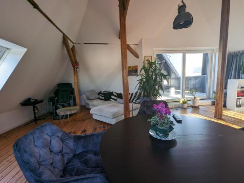 - un salon avec une table et deux chaises dans l'établissement Luxuriöses Penthouse mit Dachterrasse & Massagesessel EM-APARTMENTS DEUTSCHLAND, à Bielefeld