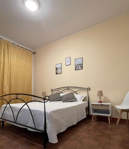 a bedroom with a bed with white sheets and pillows at Mura Guest Room in Terralba