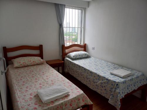 um quarto com duas camas e uma janela em Hospedaria Residencial da Torre no Recife