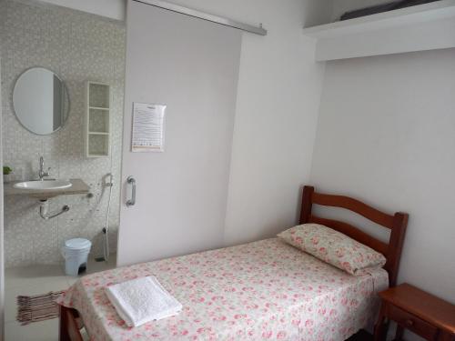 um quarto com uma cama, um lavatório e um espelho em Hospedaria Residencial da Torre no Recife