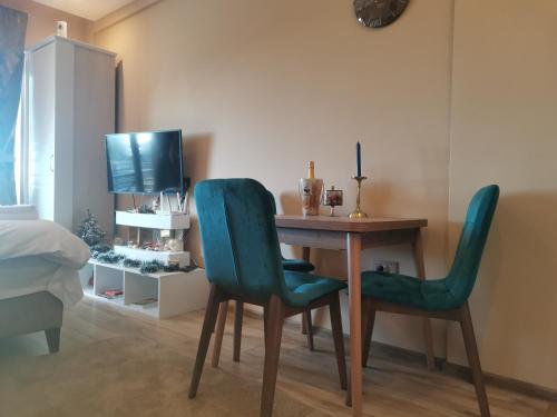 a room with a desk with two chairs and a television at BELVEDERE A9 ( N LUX MILMARI RESORT) in Kopaonik