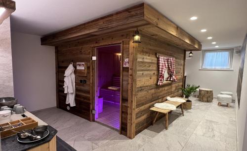 a bathroom with a wooden wall with a purple shower at B&B Obermair in Brunico