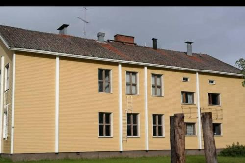 un gran edificio amarillo con ventanas y techo en Guesthouse Pekkala, en Rovaniemi