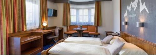 a hotel room with a bed and a desk at Alte Post in Ellmau