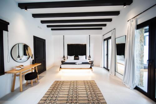 um quarto com uma cama e uma secretária em Agrari Bo Suites by Mykonos Rocks em Agrari