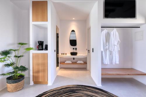 a bathroom with white walls and a tv on a wall at Agrari Bo Suites in Agrari