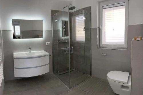a bathroom with a shower and a sink and a toilet at Villa SeaBreeze in Kali