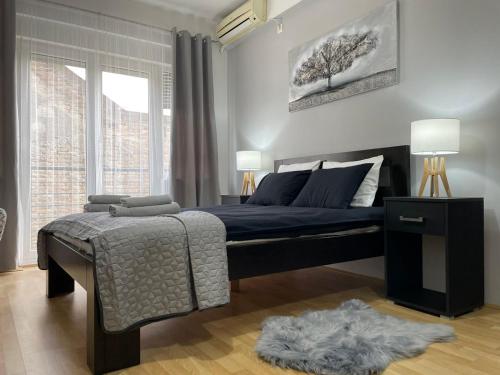 Un dormitorio con una cama azul y una ventana. en Apartments TEMA, en Sombor