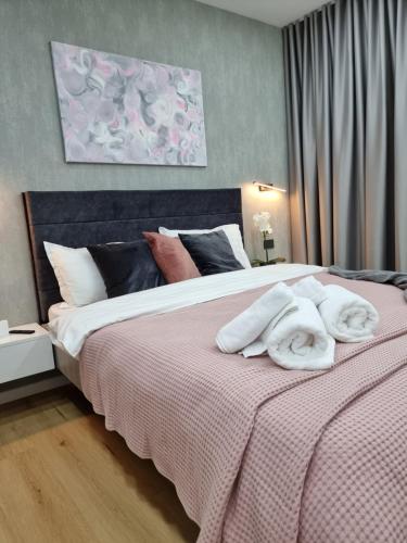 une chambre avec un grand lit avec des serviettes dessus dans l'établissement Casa Chiper - Apartament Etaj 1, à Braşov