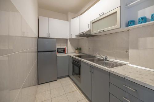 a kitchen with a sink and a refrigerator at Apartment Marina in Novi Sad