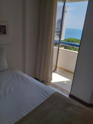 um quarto com uma cama e vista para o oceano em Atlantic City Apart em Salvador