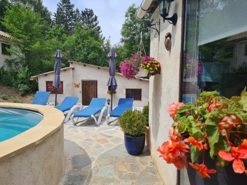 une terrasse avec des chaises bleues et une piscine dans l'établissement Maison Castellane Chambre d'Hotes B&B, à Castellane