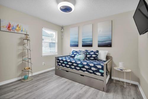 1 dormitorio con 1 cama con almohadas azules y blancas en Jax Beach Luxury Oasis W/ Private Pool/Jacuzzi Tub, en Jacksonville Beach