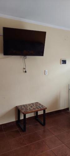 una mesa frente a una pared con TV en ApartMallki en Cafayate