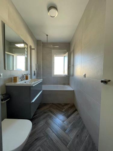 a bathroom with a tub and a sink and a toilet at Piso playa Maktub in Puerto Real