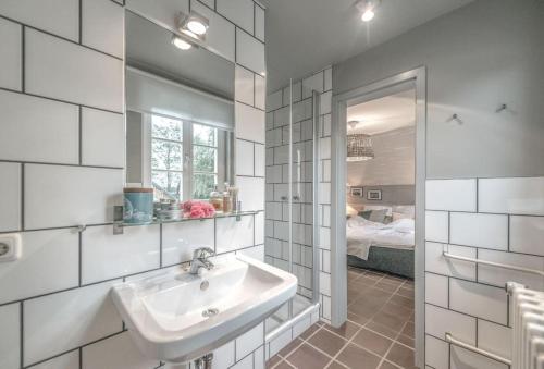 La salle de bains est pourvue d'un lavabo, d'un miroir et d'un lit. dans l'établissement Anker.Punkt: Einzigartiges Ferienhaus in Rieth am See, à Rieth