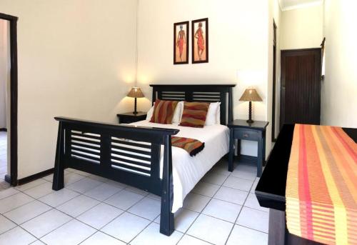 a bedroom with a black bed and two night stands at Ocean View Villas in Ballito