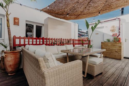 une terrasse avec un canapé, une table et des chaises dans l'établissement Hôtel PALMITO, à Biarritz