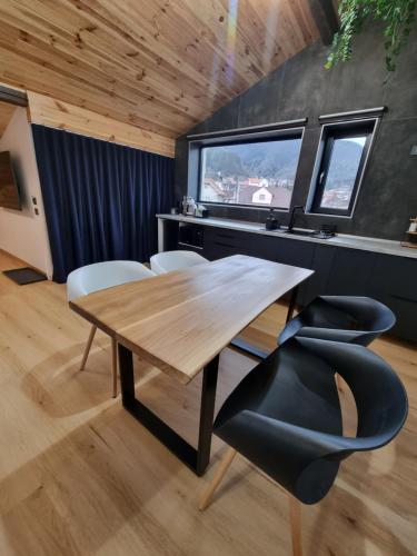 a dining room with a wooden table and chairs at Casa Chiper - Attic apartment with view in Braşov