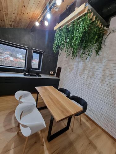 a dining room with a table and two white chairs at Casa Chiper - Attic apartment with view in Braşov