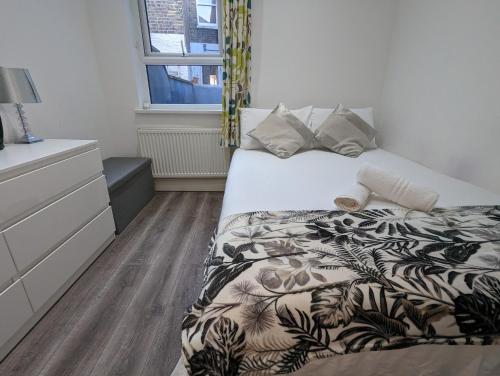 a bedroom with a bed and a dresser at Mile End- Prime location in London