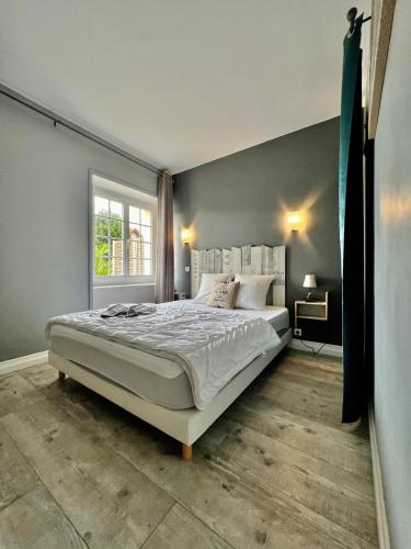 une chambre avec un grand lit et une fenêtre dans l'établissement La Rose Des Vents, à Grandcamp-Maisy