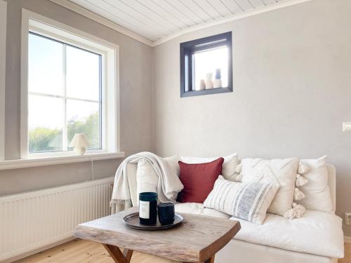 a living room with a white couch and a table at Lovely, bright apartment overlooking nature in Fiskebäckskil