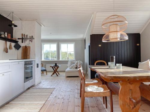 a kitchen with a wooden table and a dining room at Lovely, bright apartment overlooking nature in Fiskebäckskil