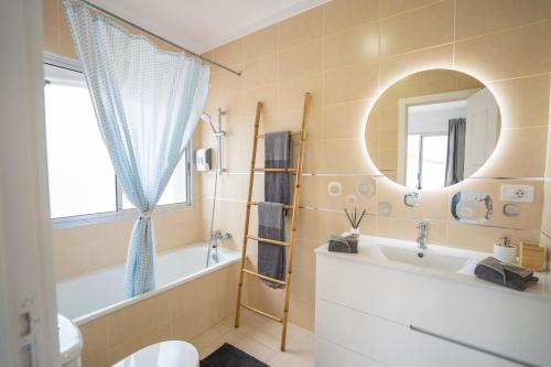 a bathroom with a tub and a sink and a mirror at Ocean Vibes with sea view and private heated pool in Callao Salvaje