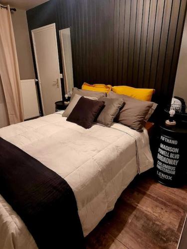 - une chambre avec un grand lit et des oreillers bruns dans l'établissement Le Mans Factory - Parking Gratuit - Proche Hypercentre, au Mans