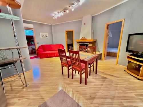 a living room with a table and chairs and a television at JAUNA apartments in Jūrmala