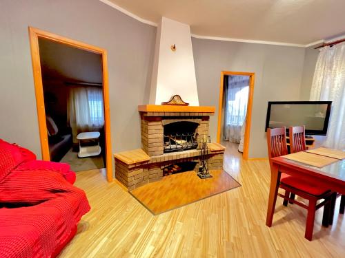 a living room with a brick fireplace and a table at JAUNA apartments in Jūrmala