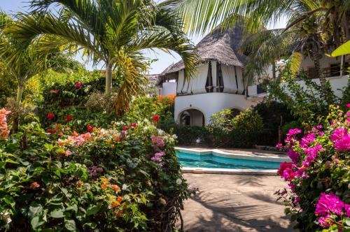 a villa with a garden and a swimming pool at Rischland Villas in Watamu