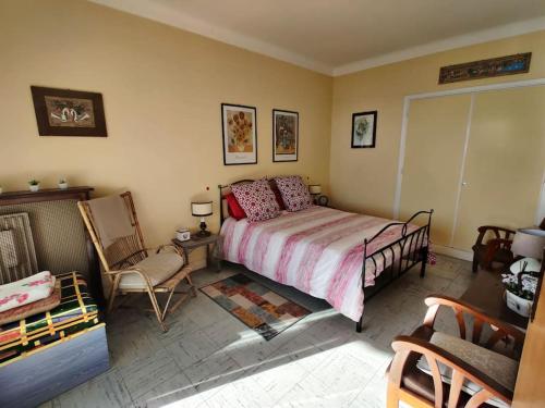 une chambre avec un lit et une chaise dans l'établissement Vintage flat on Villefranche bay - free car park, à Villefranche-sur-Mer