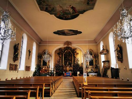 a church with christmas trees and pews at Haus Hubertus in Bad Peterstal-Griesbach