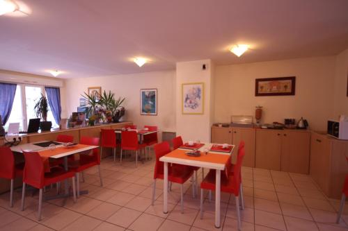 un restaurant avec des chaises et des tables rouges et une cuisine dans l'établissement Résidence Côté Sud La Bouilladisse, à La Bouilladisse