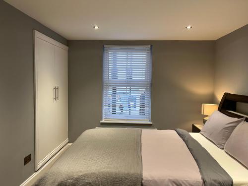 a bedroom with a large bed and a window at Luxury 1 bed apartment + 1 Sofa Bed Can sleep Up To 4 People 5 Mins Barnet Station Free Parking in Barnet