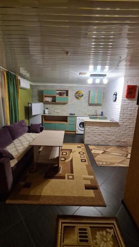 uma sala de estar com um sofá e uma mesa em Vintage гостиница em Shchuchinsk