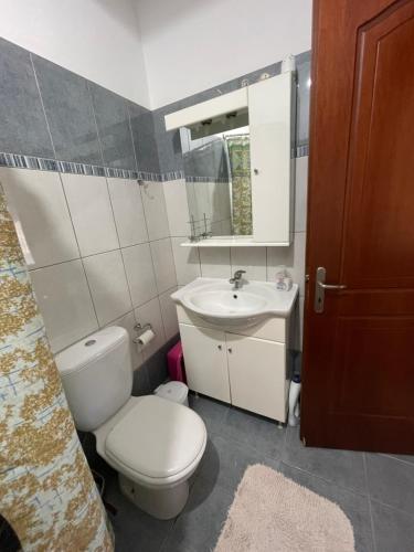 a bathroom with a toilet and a sink and a mirror at Nice Cosy apartment in Igoumenitsa in Igoumenitsa