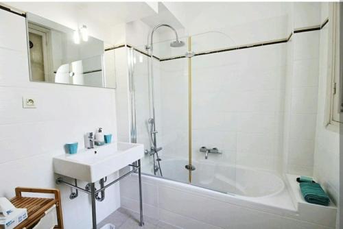 La salle de bains blanche est pourvue d'un lavabo et d'une baignoire. dans l'établissement Central, climatisé, proche Promenade des anglais., à Nice
