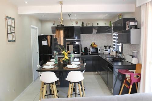 a kitchen with a table and some stools in it at Villa 4ch 4Sdb à 5min de Nantes in Sainte-Luce-sur-Loire