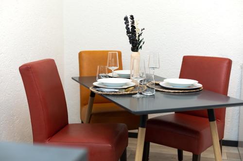 uma mesa de jantar com duas cadeiras e um vaso com flores em Entdecke das idyllische Allgäu - Verbringe deinen Traumurlaub in unserer gemütlichen Ferienwohnung em Immenstadt im Allgäu